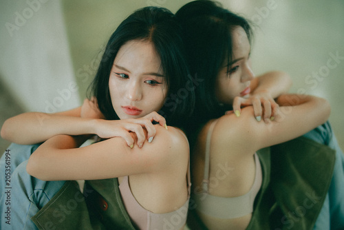 Quadro em tela Mental health awareness: A young woman leaning on a window pane, symbolizing the feeling of being trapped in sadness