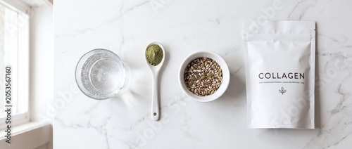 morning wellness supplement routine with collagen pouch glass of water and seeds flat lay