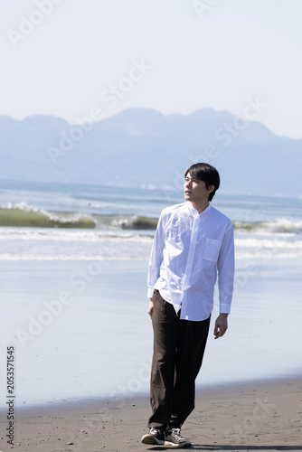 浜辺　波打ち際を歩く男性