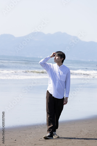 浜辺　波打ち際を歩く男性