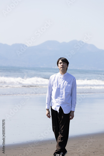 浜辺　波打ち際を歩く男性