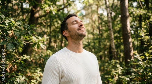 Tapety artystyczne Relaxed adult man breathing fresh air in a lush green forest.