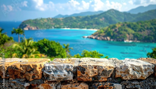 Stone wall view of tropical bay, turquoise sea, lush green hills