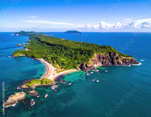 Aerial view of a lush green island with clear turquoise water and sandy beaches