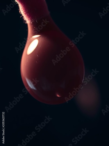 Pearlescent teardrop, slick with shadow, clinging to velvet A silent, glistening drama,  glossy surface,  glistening drop