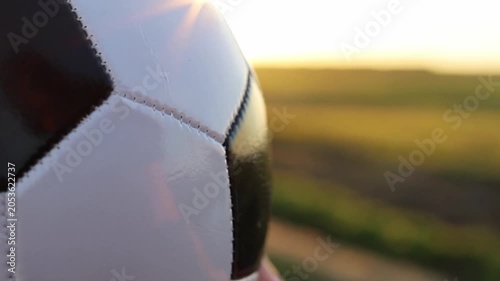 Close up of a soccer ball on a green field at dusk. The setting sun casts a warm glow, setting the stage for the highly anticipated 2026 World Cup hosted by Canada and the USA