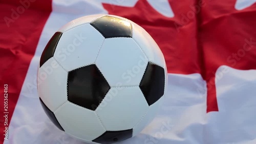 A classic black and white soccer ball rests on a Canadian flag. This represents Canada's part as a co-host for the  World Cup 2026, joining USA and Mexico