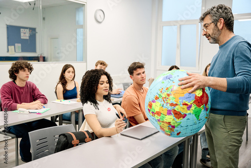 Fotografie Geography teacher explaining world globe to university students