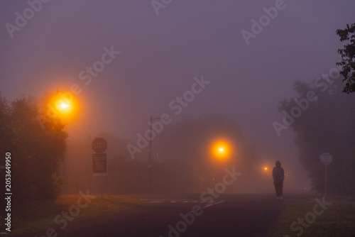 pre dawn fog settling on road illuminated by street lights