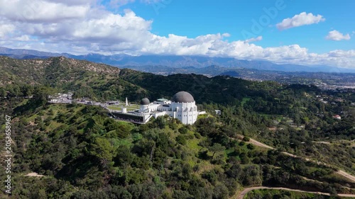 Griffith Observatory aerial view on hilltop with mountains and clouds Los Angeles California