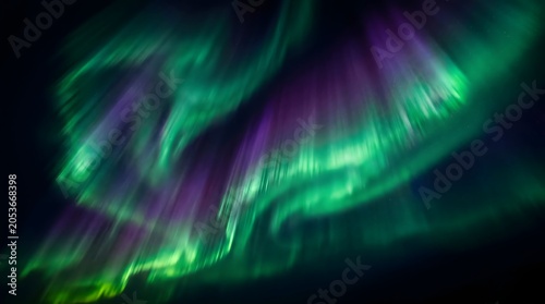 Vibrant aurora borealis display over dark landscape northern lights