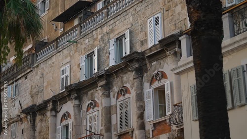 Historic stone building facade with shutters.
