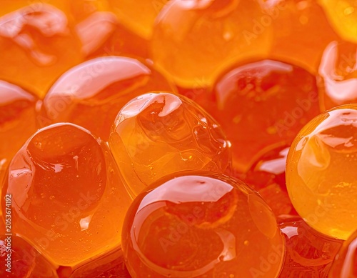 Macro view of translucent, bright orange spheres, glistening with a wet sheen