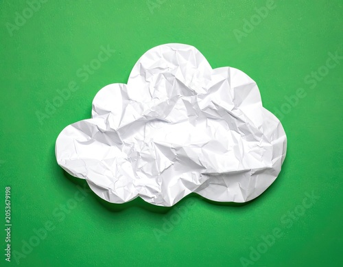 Crinkled white paper cloud shape on a vibrant green background