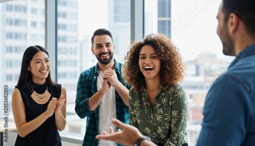 Diverse group of colleagues celebrating success and laughing together in a modern office setting.