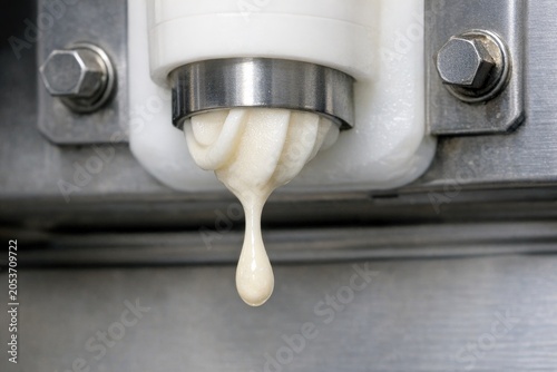 A close-up view of a machine with liquid flowing out, suitable for use in industrial or mechanical context