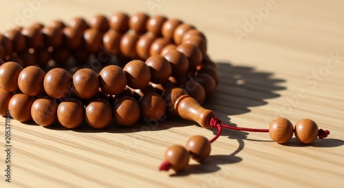 Wooden mala prayer beads resting on a light wooden table for meditation