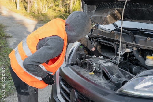 Schilderij op canvas roadside assistance worker inspecting engine compartment of broken delivery van