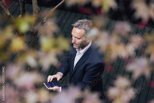 Business Professional Using Phone Surrounded by Nature