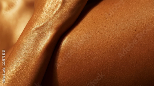 Ultra close up abstract texture of smooth golden glowing sun kissed skin and arm texture