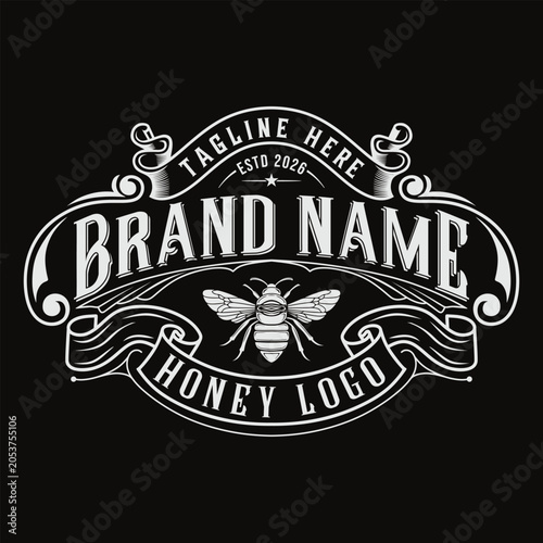 Vintage honey bee logo design element with ornate filigree frame and ribbon banners on a dark background, perfect for organic farm branding, product labels, or retro packaging.