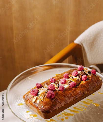 Fotografía Delicious loaf cake with berries and nuts on a glass plate at a cafe