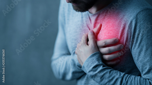 Man clutching his chest in pain, suffering from heart attack