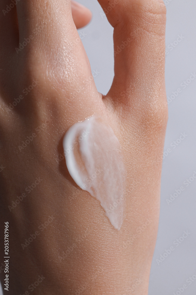 Fototapeta premium female hand with a cream swatch on it, cream on a hand
