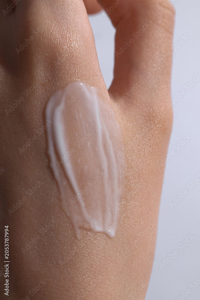 Fototapeta premium female hand with a cream swatch on it, cream on a hand