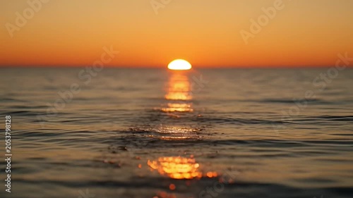 Ocean sunset with vibrant orange sunlight reflecting on the water surface