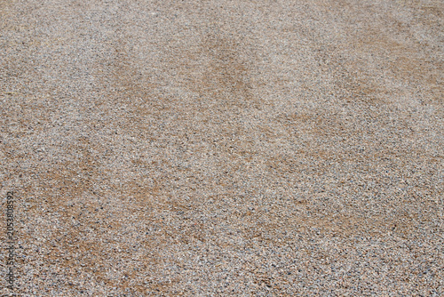 Canvas Print Gravel road surface background with fine grey stones and brown sand texture