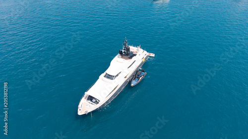 Canvastavla Luxury Yacht at Sea: An opulent yacht floats serenely on the crystal-clear blue ocean, showcasing its sleek design and immense size against a backdrop of pure tranquility
