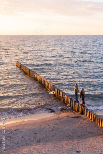 mother and daughter by the sea at sunset
