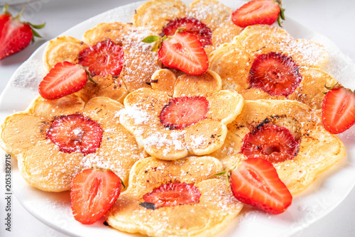 Viral summer breakfast Strawberry Flower Pancakes, sweet tasty fluffy pancakes with slice of fresh raw strawberry in the middle, kids morning and lunch food idea