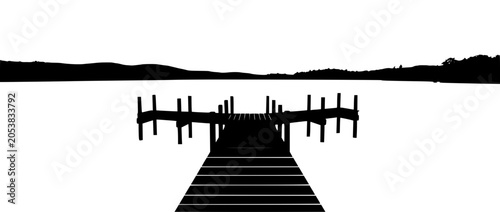 silhouette of a wooden pier on a calm lake with mountains in background