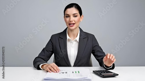 Professional woman in business attire calculating financial data indoors