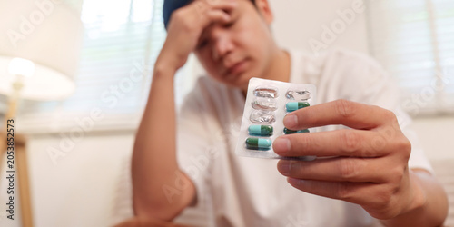 Foto Asian man holding medication pills blister pack for healthcare illness treatment