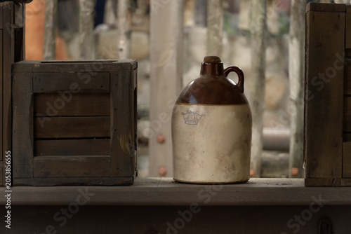 Foto Vintage moonshine stoneware jug on rustic shelf