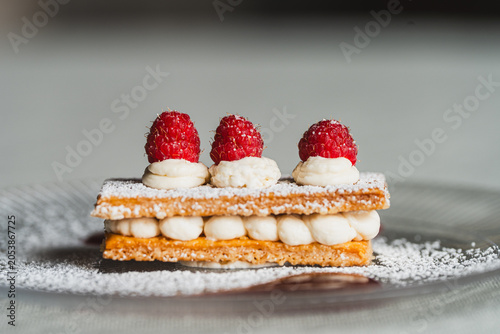 Fényképezés postre de milhojas de nata, azúcar glas y moras rojas