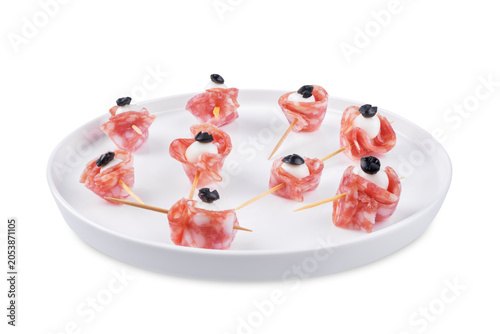 Mozzarella sausage olive canape in the form of eye in a plate on a white isolated background