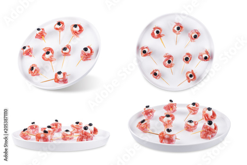 Mozzarella sausage olive canape in the form of eye in a plate on a white isolated background