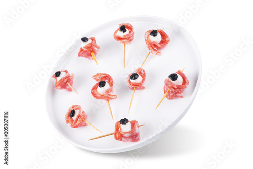 Mozzarella sausage olive canape in the form of eye in a plate on a white isolated background