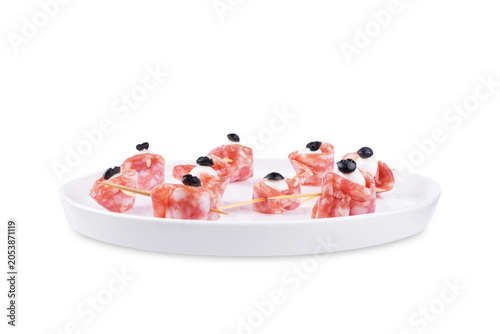 Mozzarella sausage olive canape in the form of eye in a plate on a white isolated background