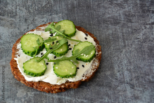 Cucumber and Cream Cheese Sandwich with arugula and sesame seeds on Dark Background