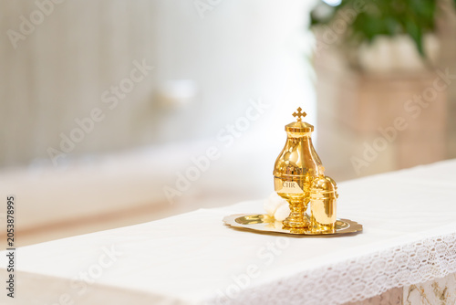 Cuadro en lienzo Golden chrism oil vessel placed on a white altar prepared for Catholic baptism c