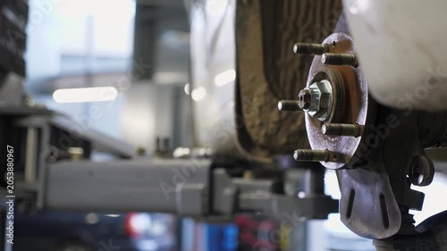 Close-up of an auto mechanic replacing brake pads on a car wheel at a service station. The auto mechanic is repairing a car in his workshop. The employees of the car service are repairing the car.