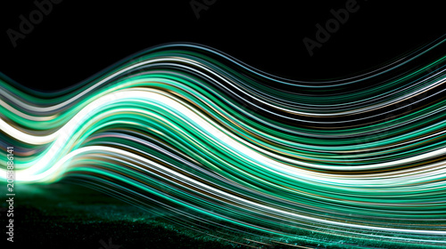 Dynamic green and white glowing light streaks forming a wave on a black background