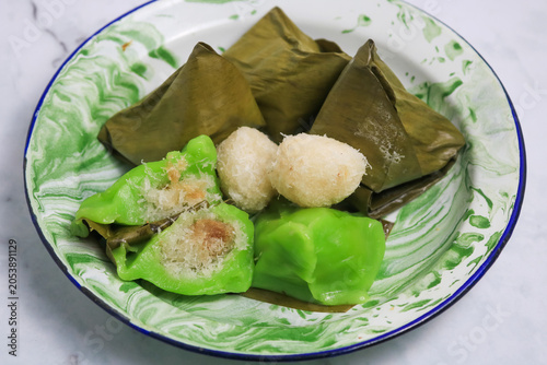 Traditional Indonesian Mendut cake with pandan leaves. Javanese sweet snack is made from glutinous rice flour, coconut and palm sugar, then wrapped in banana leaves and steamed. white backround.