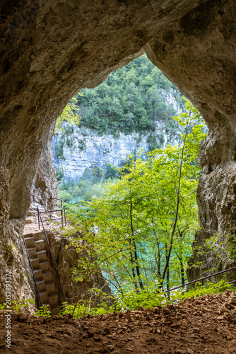 View of a turquoise lake through a cave opening in Plitvice Lakes National Park, Croatia