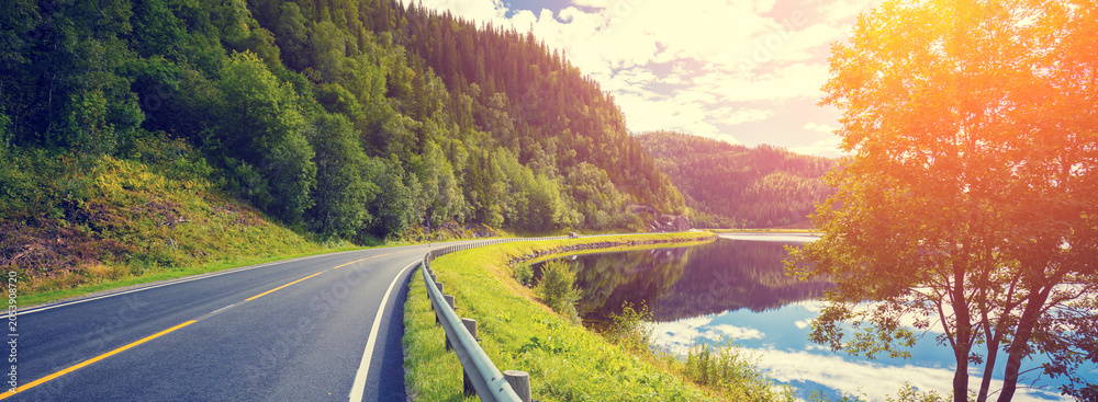 Fototapeta premium Driving a car on a mountain road along the fjord. Nature Norway